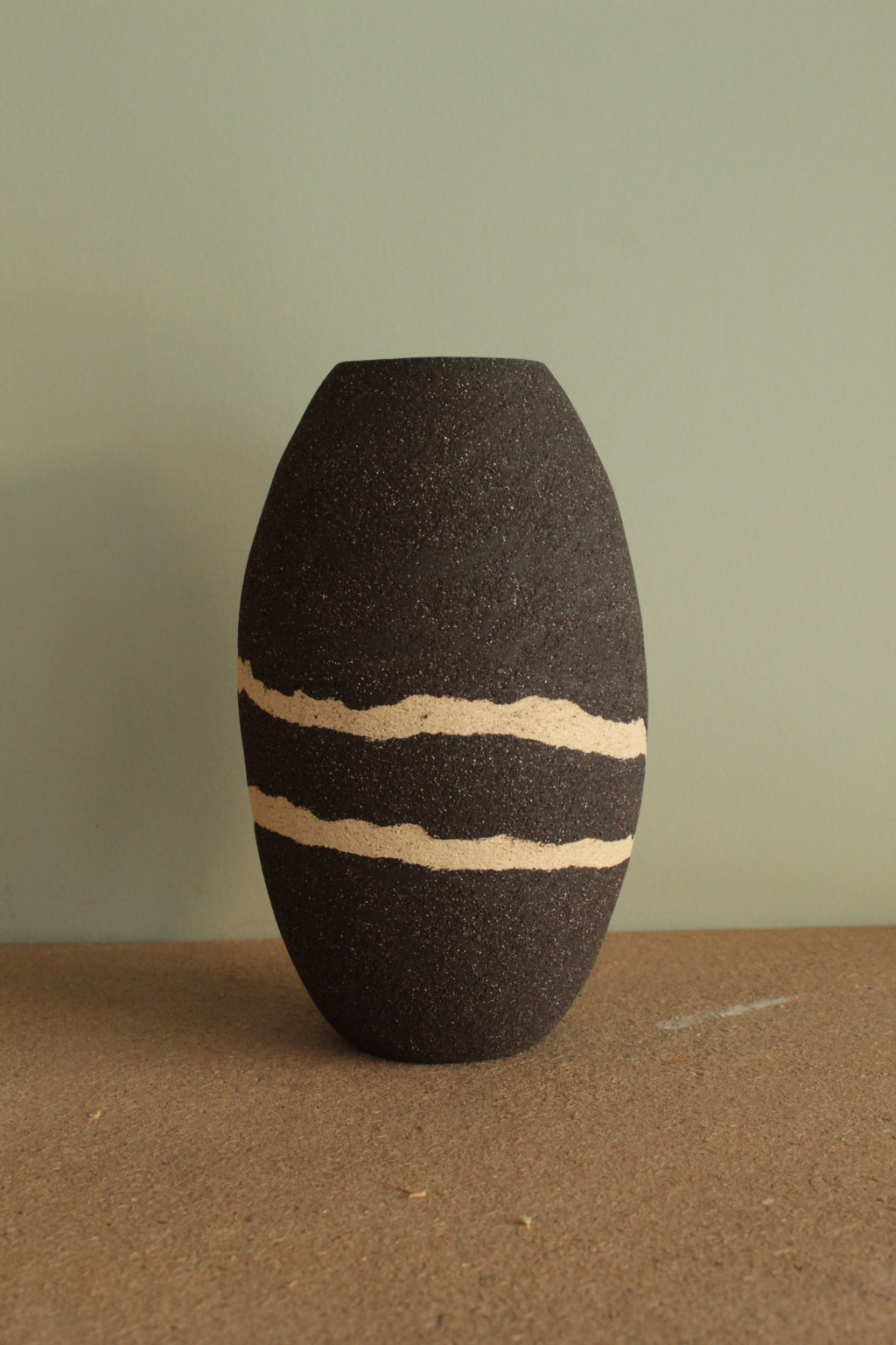 Black vase with white lines