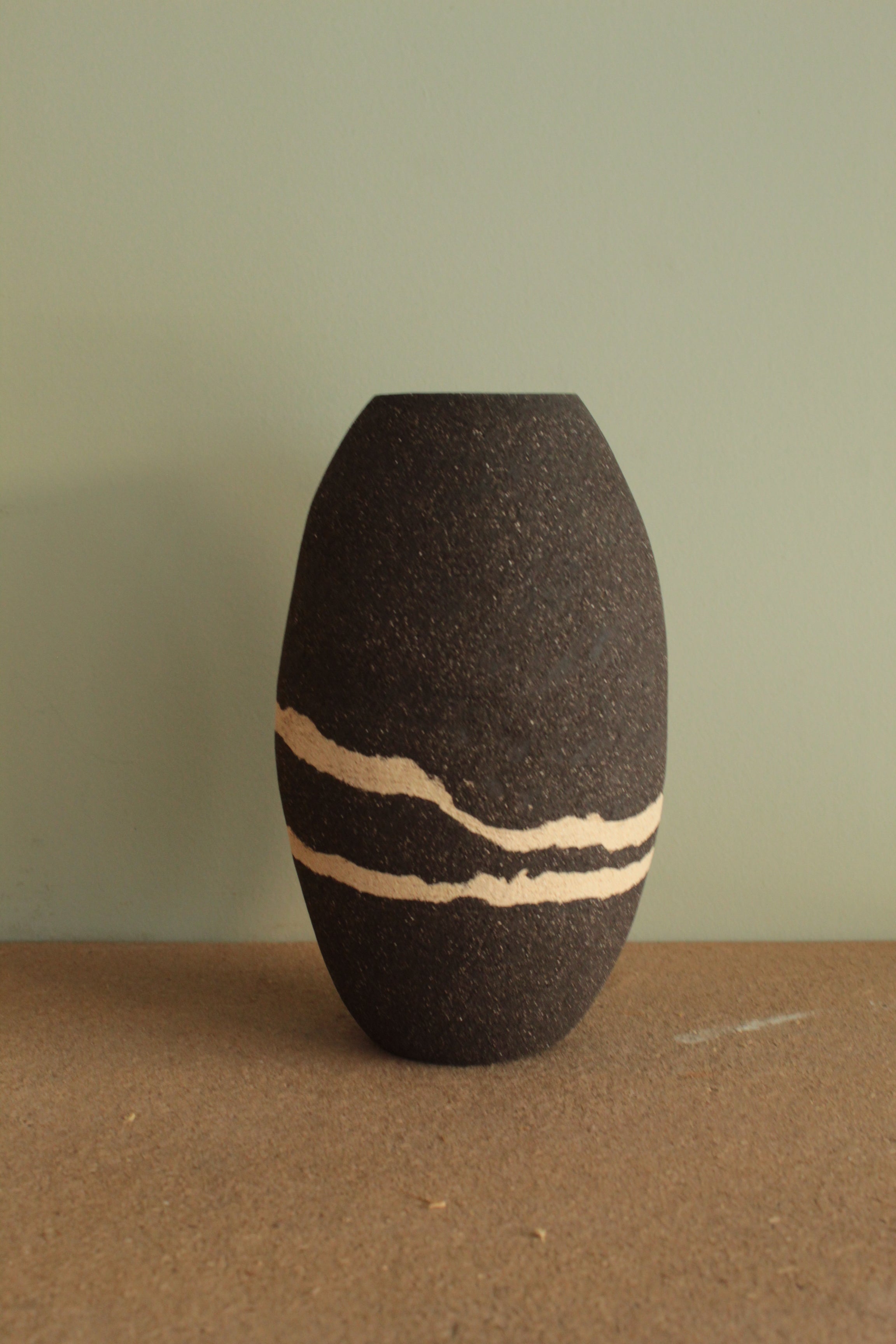 Black vase with white lines