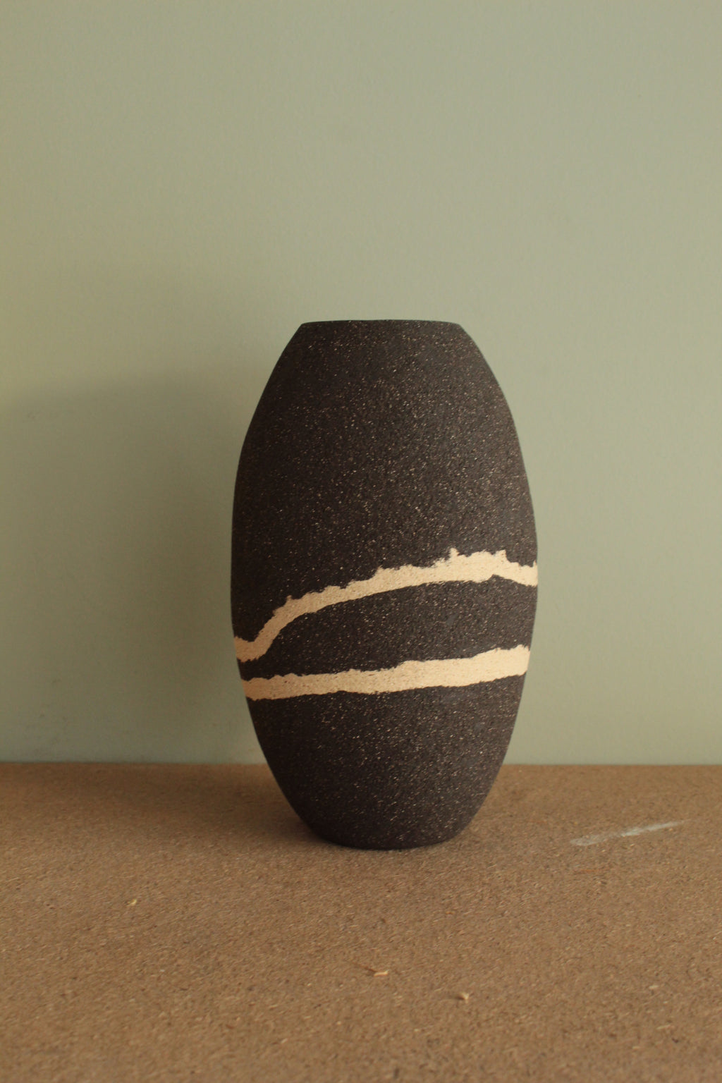 Black vase with white lines