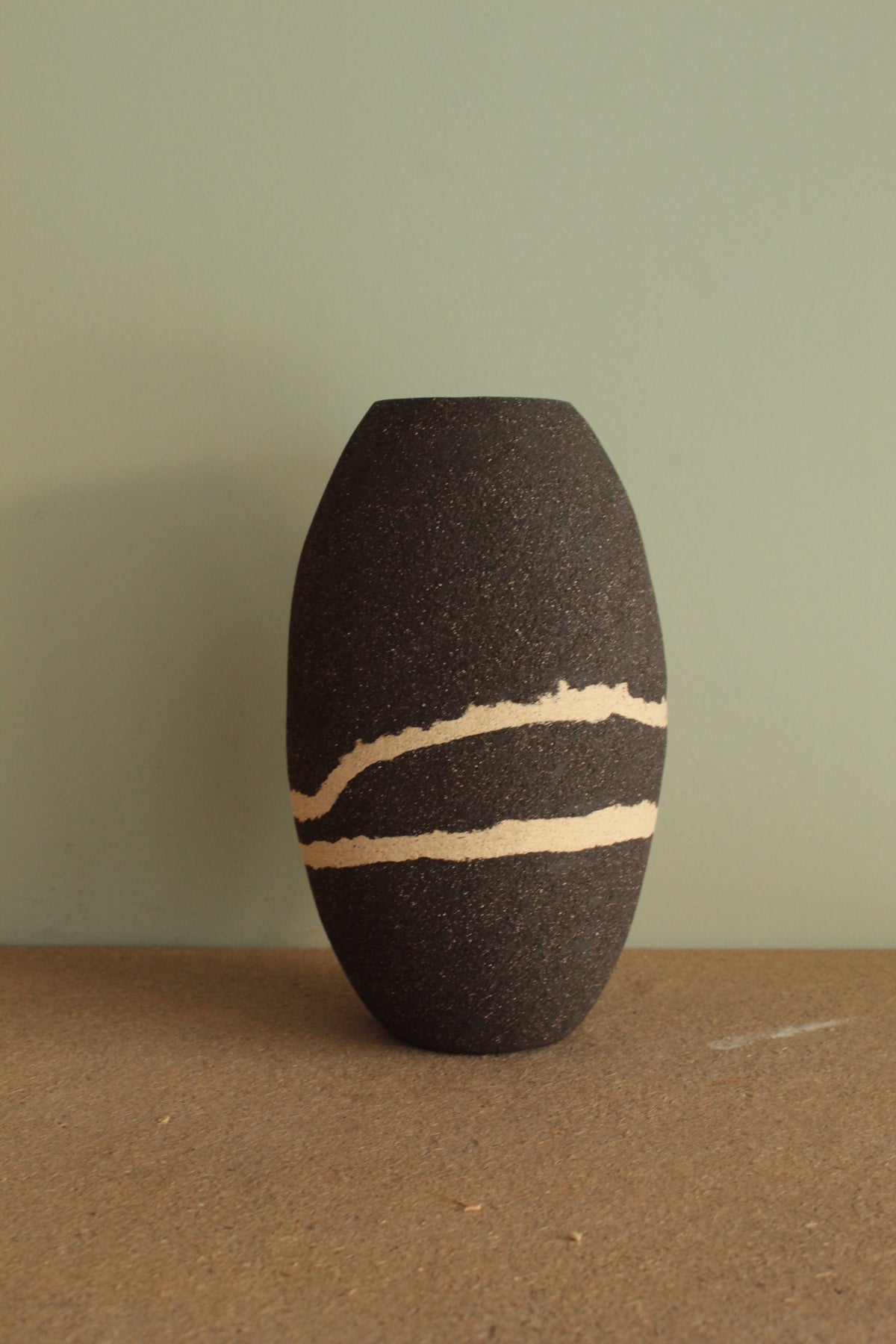 Black vase with white lines