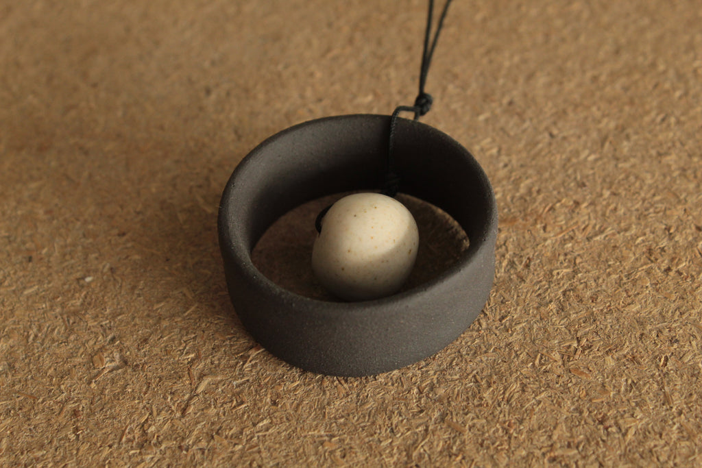 Black wheel and white stone necklace