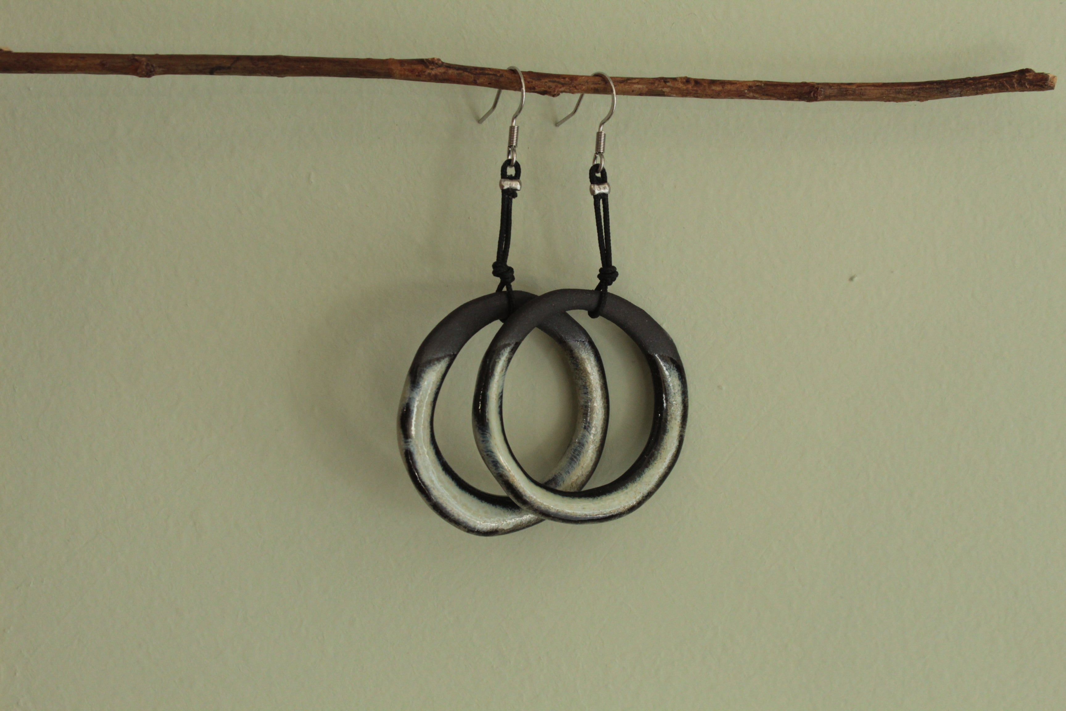 Black and beige hoop dangling earrings with cord