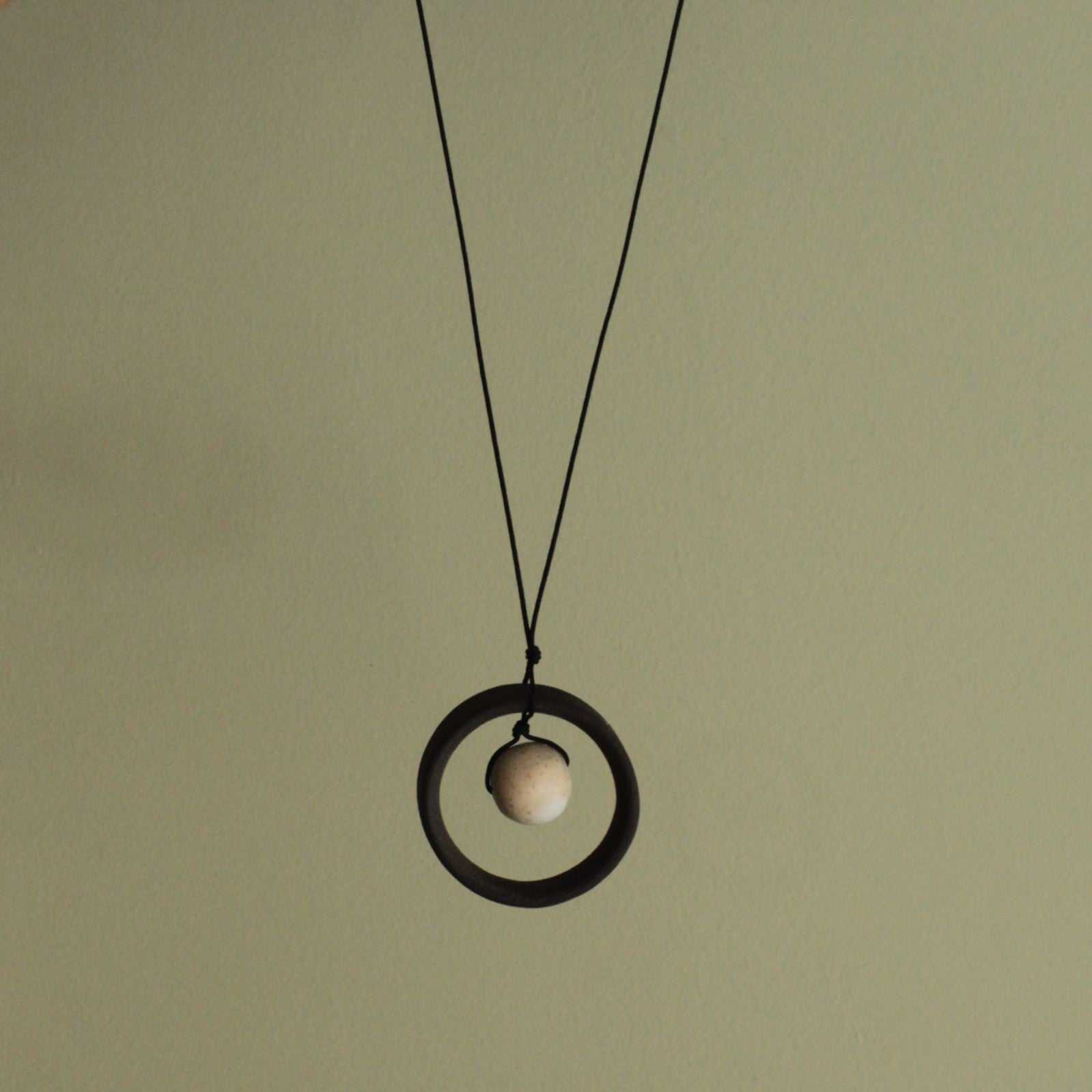 Black wheel and white stone necklace