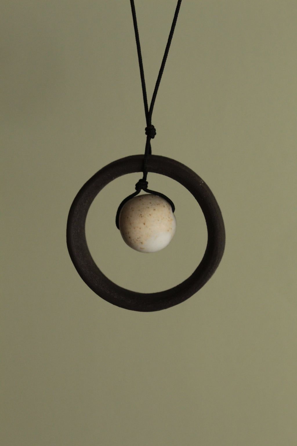 Black wheel and white stone necklace