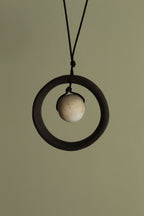 Black wheel and white stone necklace