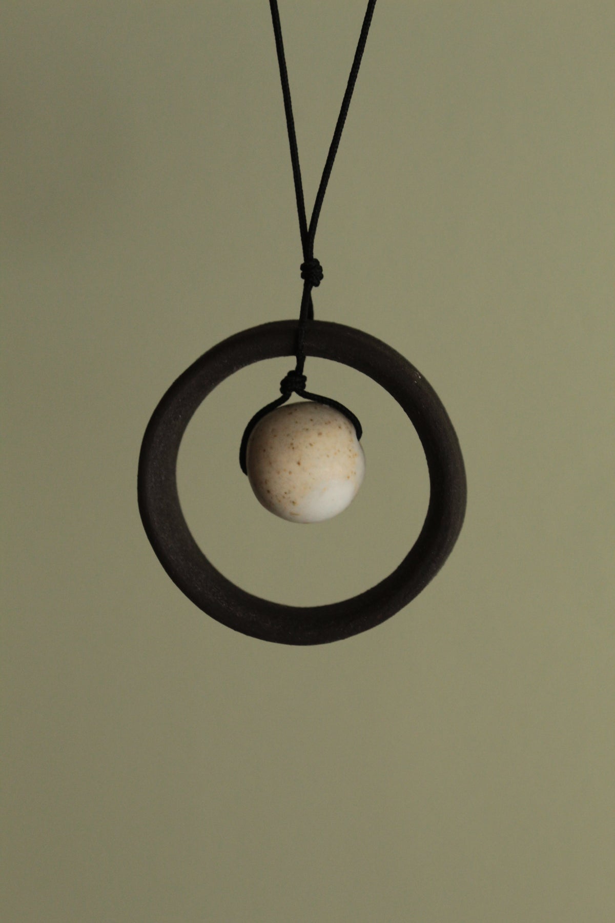 Black wheel and white stone necklace