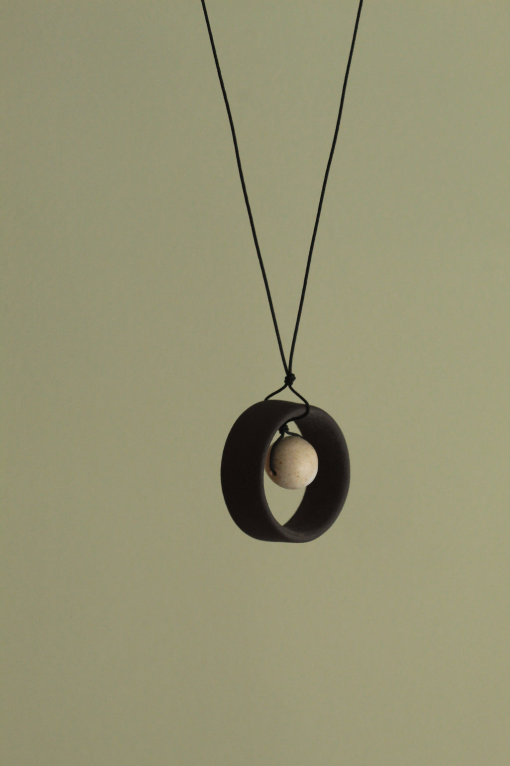 Black wheel and white stone necklace