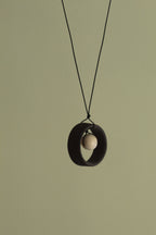 Black wheel and white stone necklace