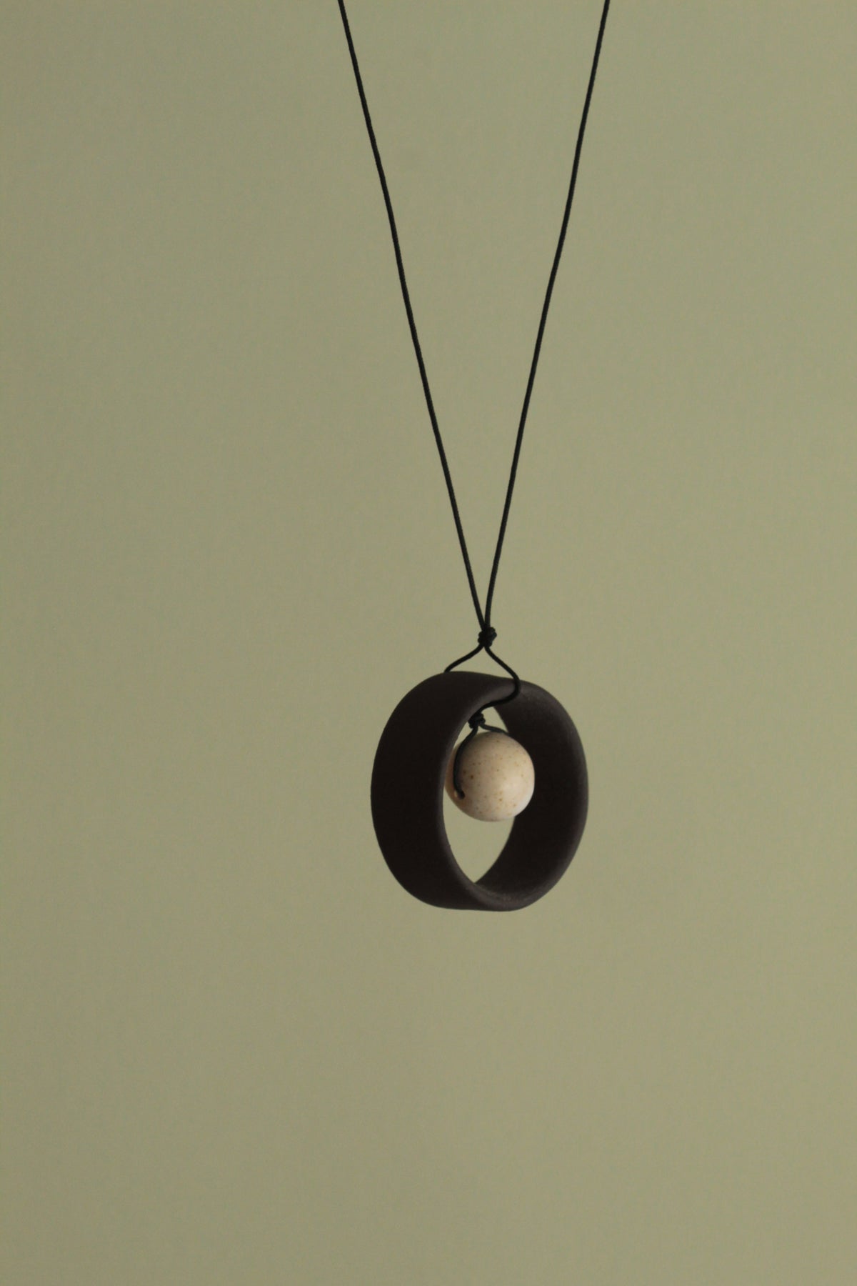Black wheel and white stone necklace