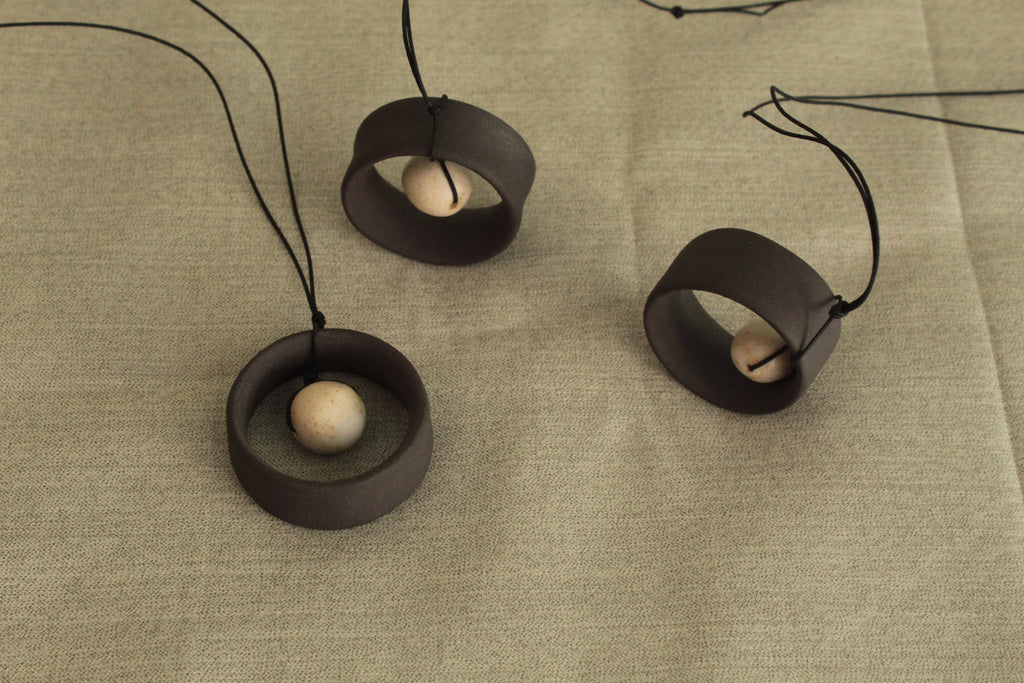 Black wheel and white stone necklace