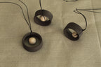 Black wheel and white stone necklace