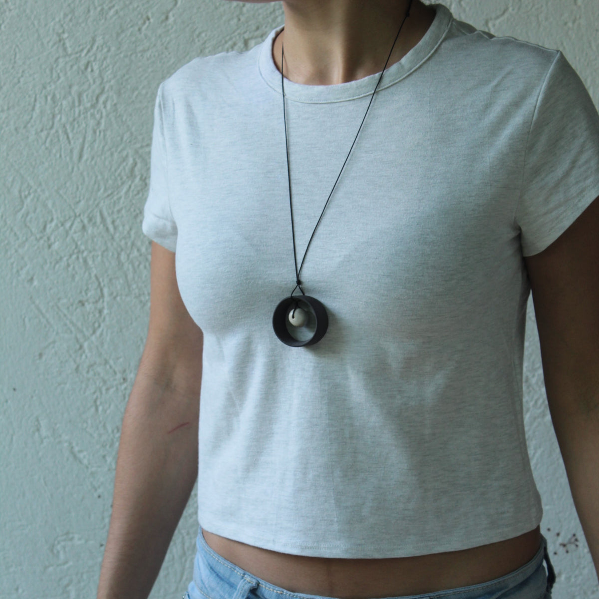 Black wheel and white stone necklace