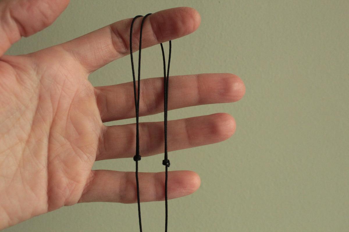 Black wheel and white stone necklace