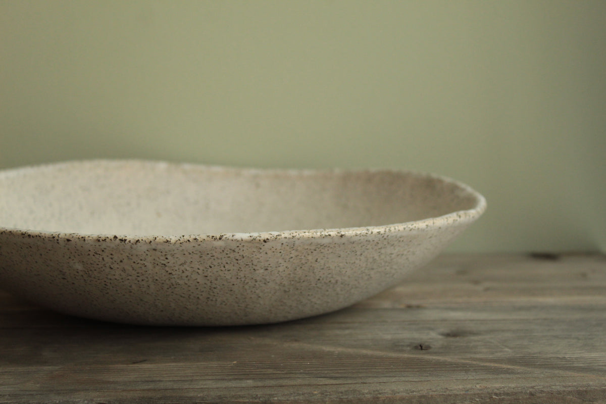 White platter/ bowl with black stones