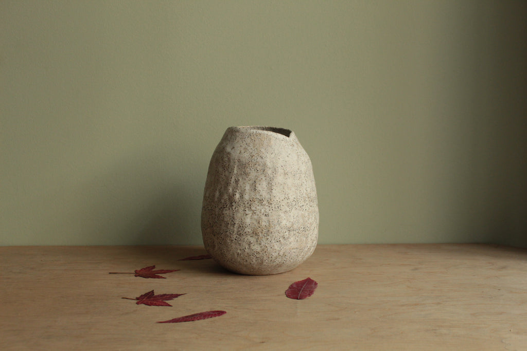 White vase with black rocks