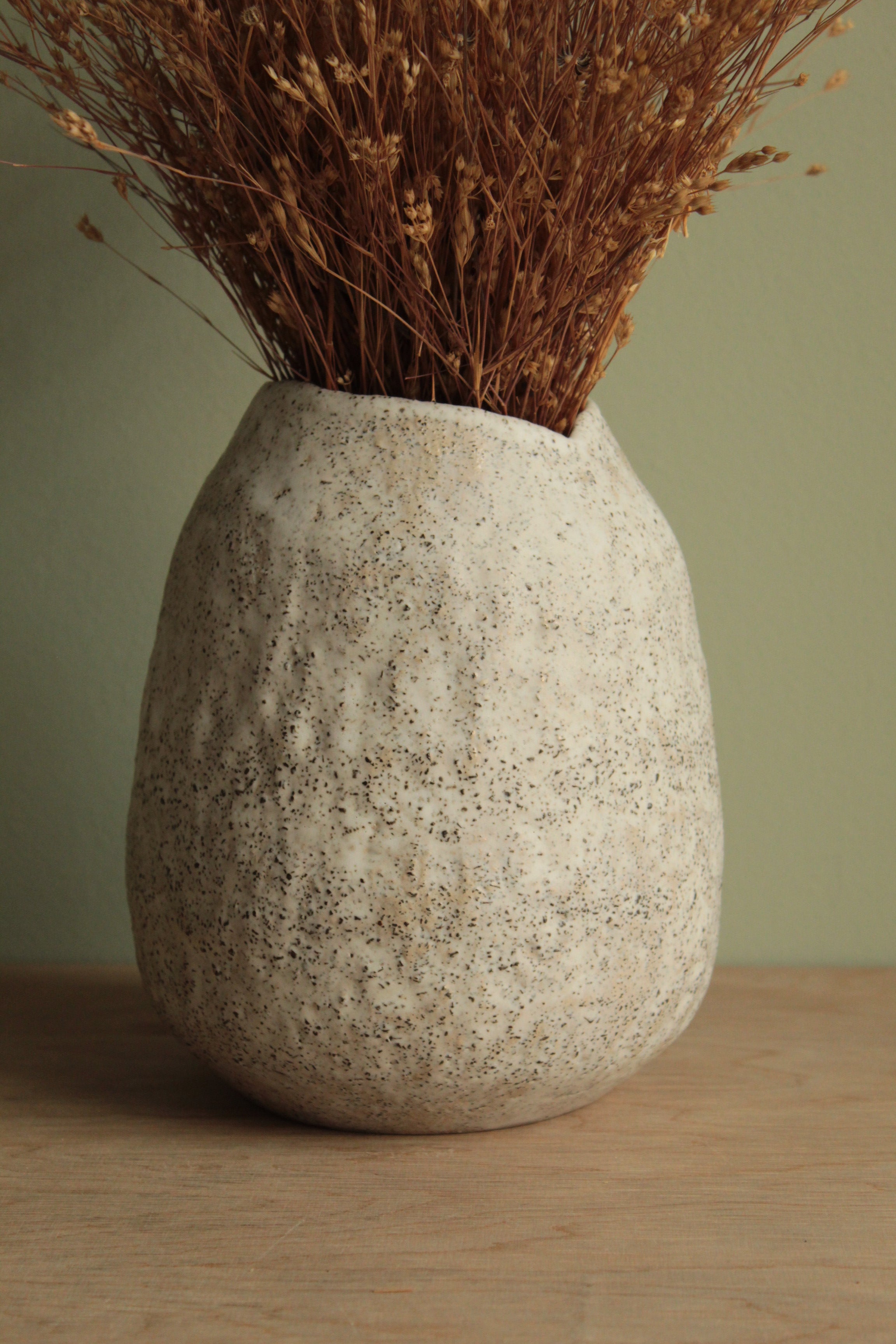 White vase with black rocks