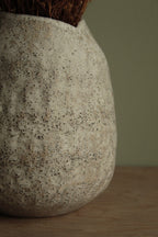 White vase with black rocks