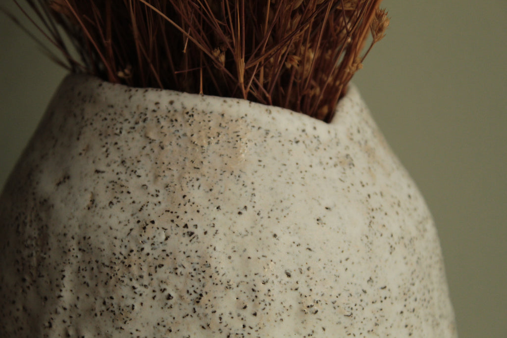White vase with black rocks