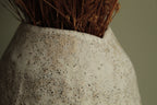 White vase with black rocks