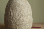 White vase with black rocks