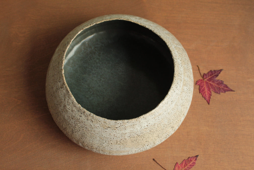 White vessel with black rocks