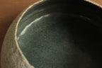 White vessel with black rocks