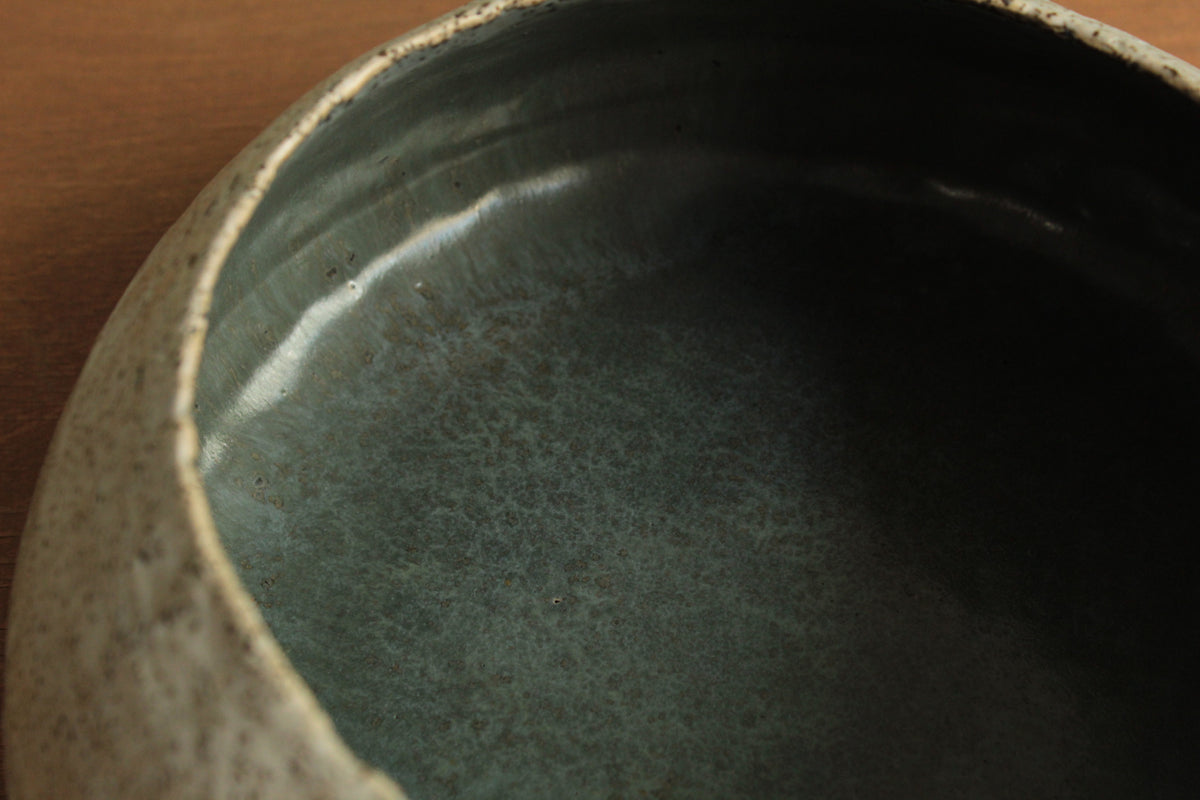 White vessel with black rocks