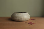 White vessel with black rocks