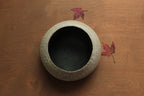 White vessel with black rocks