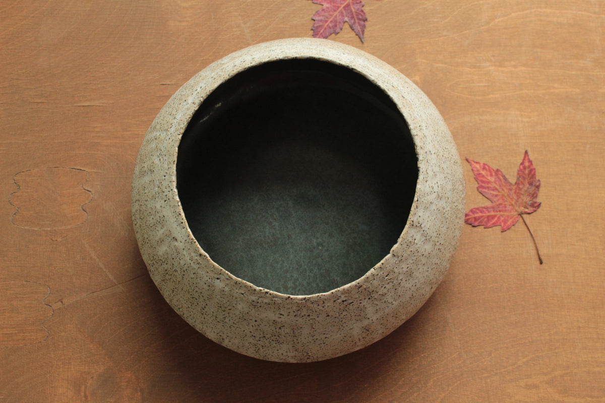 White vessel with black rocks